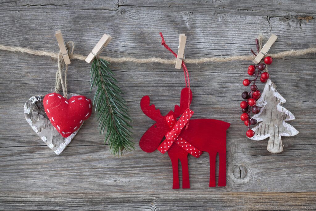 Heartfelt rustic Christmas decorations on wood, featuring a red moose, heart, and tree.